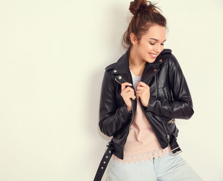Woman posing in leather jacket, showcasing trending jacket styles for women.