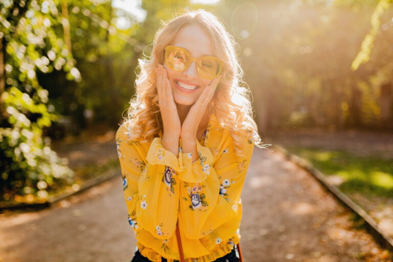 Naomi Pierce, Seashells & Sunflowers writer, in a yellow blouse and sunglasses.
