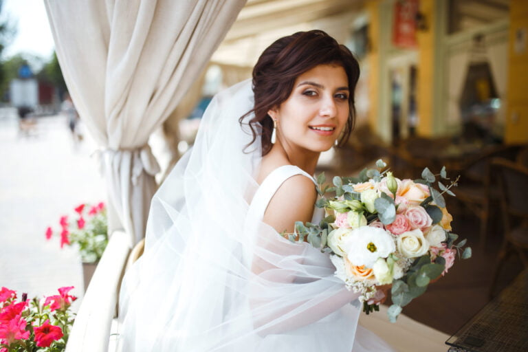 Bride with wedding flowers and veil, designing dream wedding themes