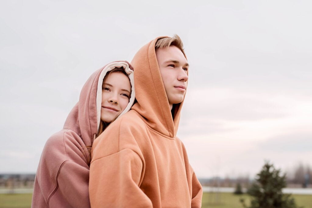 Young couple embracing wearing comfortable hoodies, demonstrating casual style